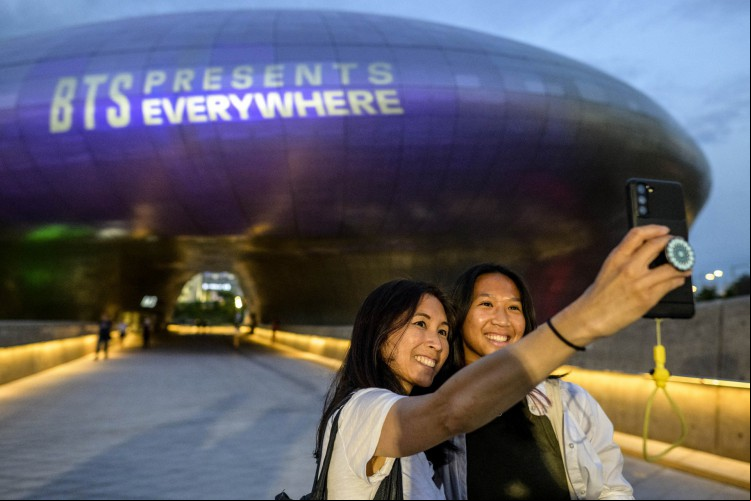 Em Seul, mãe e filha tiram foto em frente ao Dongdaemun Design Plaza todo decorado de roxo, em homenagem aos fãs do BTS Em Seul, mãe e filha tiram foto em frente ao Dongdaemun Design Plaza todo decorado de roxo, em homenagem aos fãs do BTS