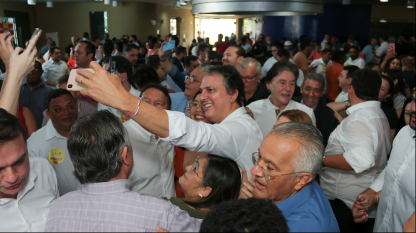 O ministro da Educação, Camilo Santana (PT), tira foto com apoiadores durante a posse do pai, Eudoro Santana, como presidente do PSB no Ceará