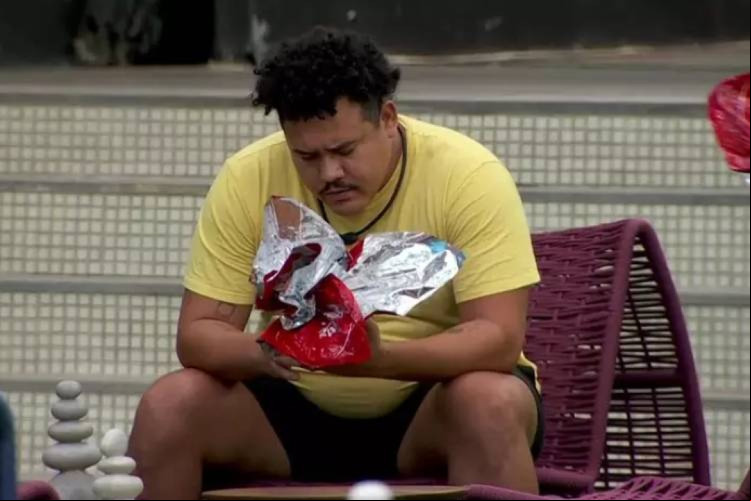 Lucas Henrique se sentou para encarar a fotografia recebida, com as duas irmãs dele, durante ação de Páscoa no BBB 24