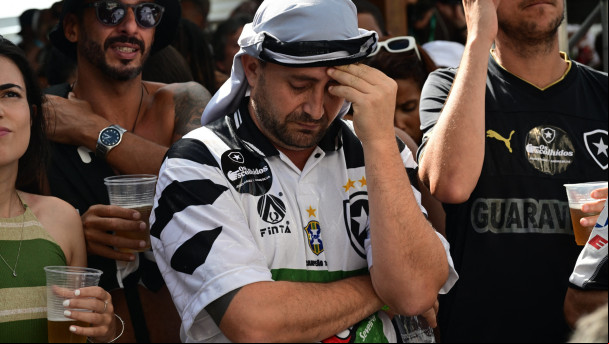 Torcedores do Botafogo reagem enquanto assistem em uma tela à partida de futebol da Copa Intercontinental da FIFA de 2024 entre o Botafogo do Brasil e o Pachuca do México na sede histórica do Botafogo, chamada General Severiano, no Rio de Janeiro