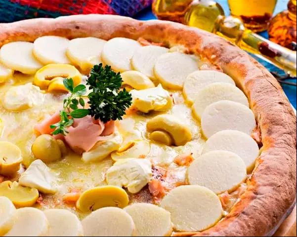 Palmito e champignon - Além dos ingredientes que dão nome à pizza, ela leva cheddar vegano e azeitonas pretas. Sugerida por Revista Vegetarianos.